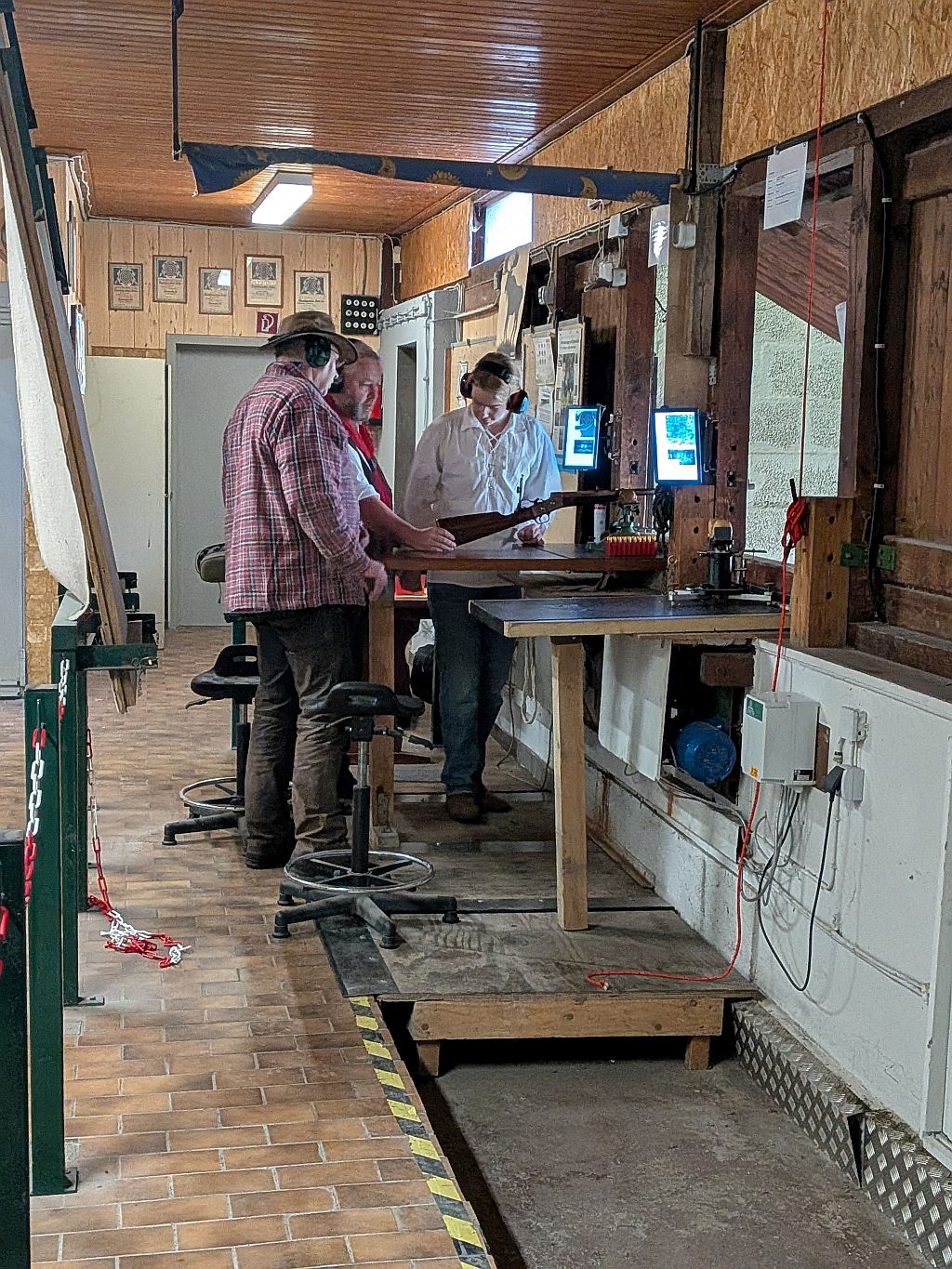 Drei Schützen mit Gehörschutz am 100-m-Stand mit Vorderladergewehr